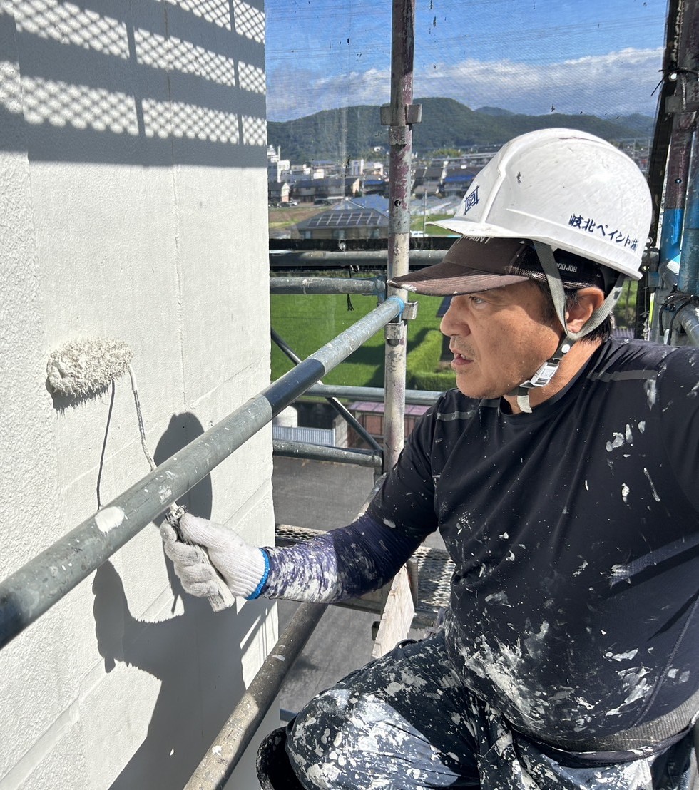 外壁を丁寧に塗装する職人